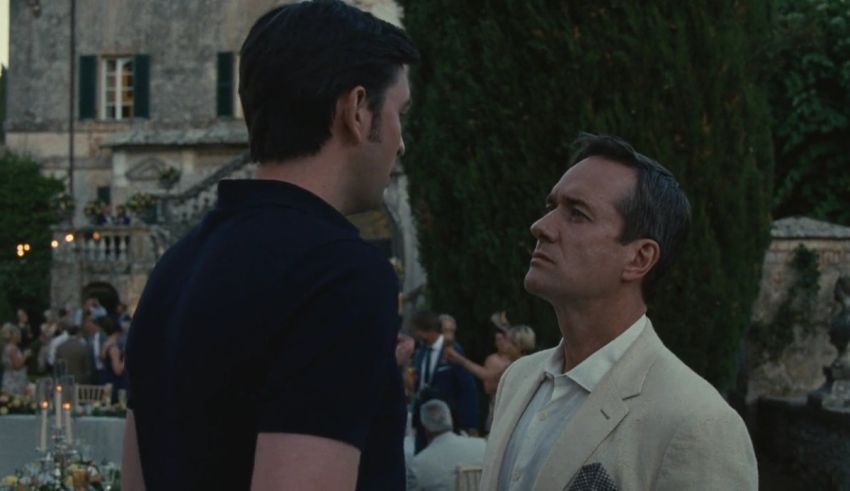 Two men standing next to each other in front of a castle.