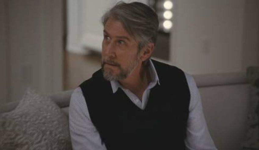 A man sitting on a couch with a beard.