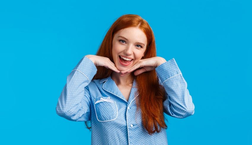 A young woman in a blue pajama posing for a photo.