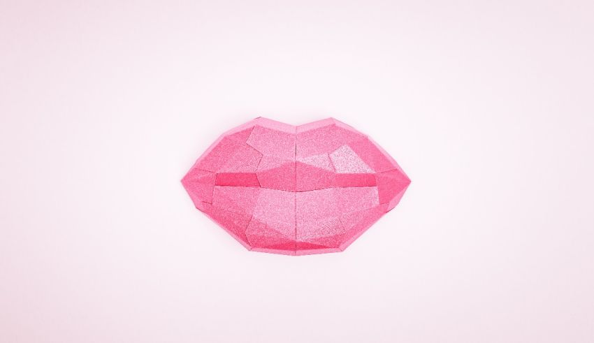 A pink origami lip on a pink background.