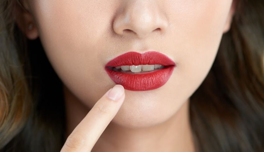 A woman is touching her lips with her finger.