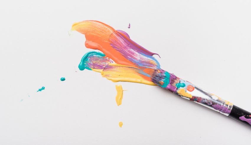A colorful paint brush on a white surface.