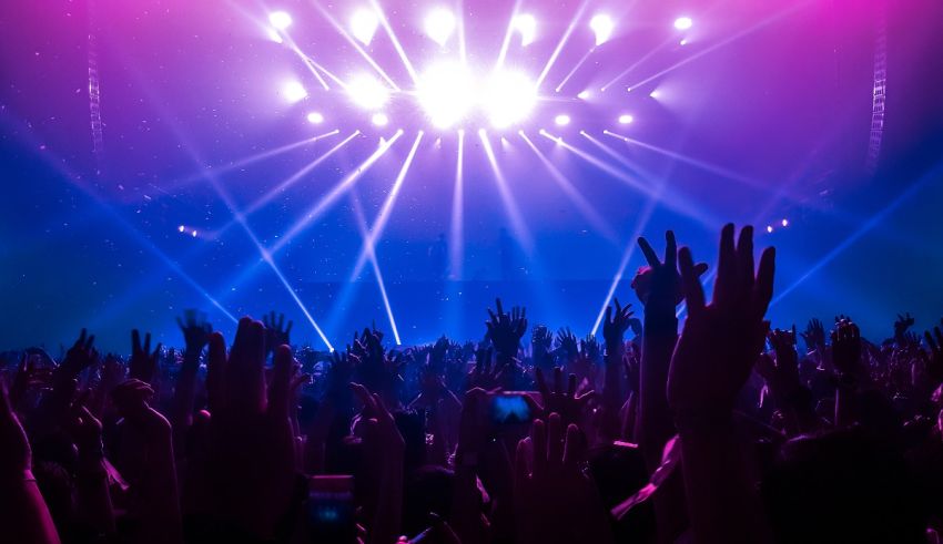 A crowd of people raising their hands at a concert.