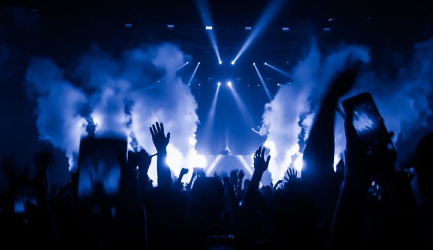 A crowd at a concert with smoke coming out of their hands.