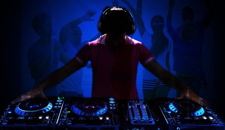 A dj is playing music in front of a crowd of people.