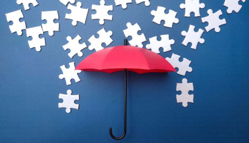 A red umbrella surrounded by pieces of jigsaw puzzles.
