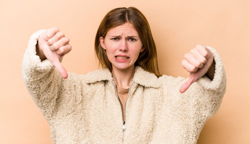 A woman in a fur coat showing her thumbs up and thumbs down on a beige background.