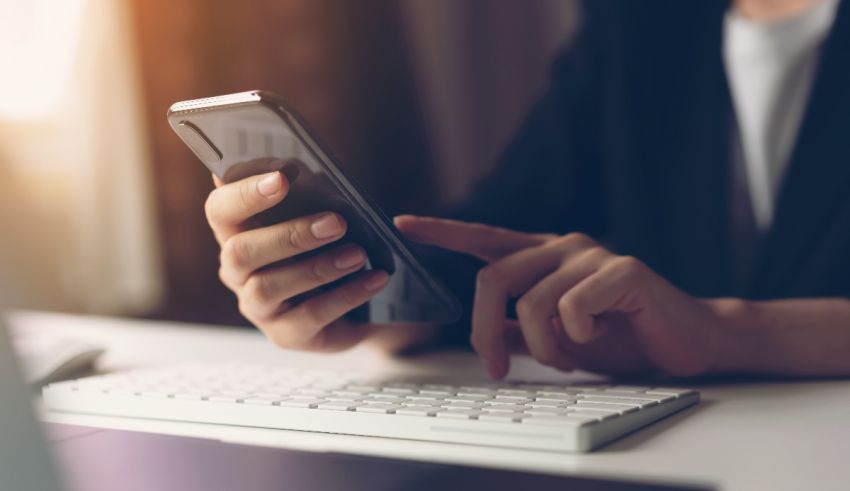 A person using a smartphone at a desk.