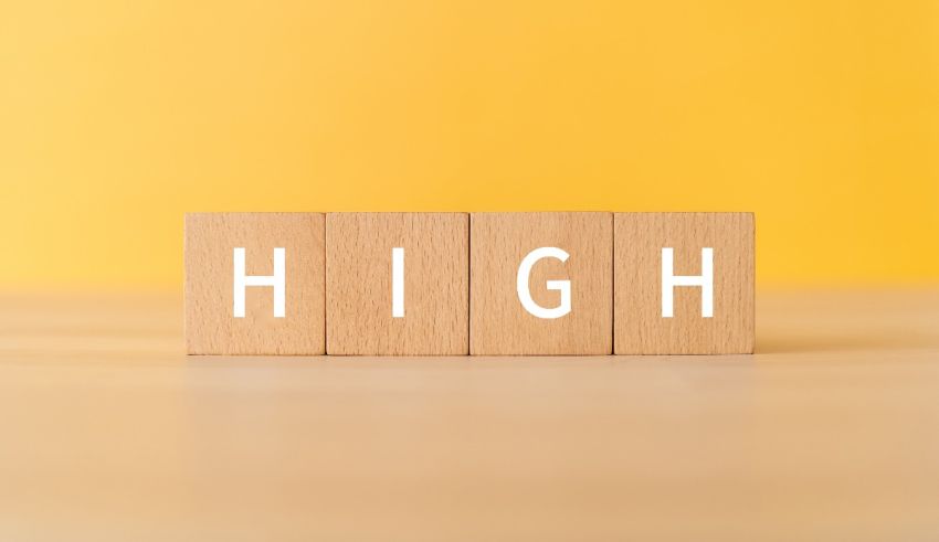 A wooden block with the word high on it.