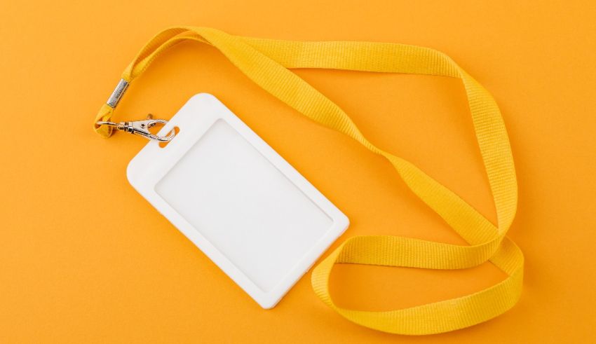 An id card with a yellow lanyard on an orange background.