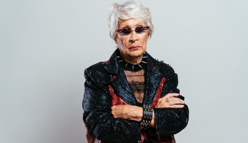 An older woman in a black jacket and glasses.