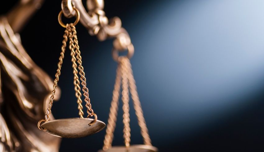 The scales of justice are shown on a dark background.
