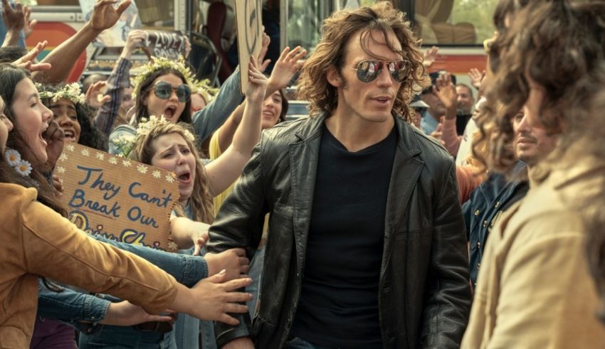 A man in a leather jacket is surrounded by a crowd of people.