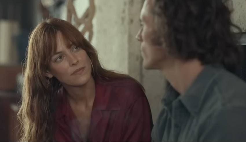 A man and woman looking at each other in a room.