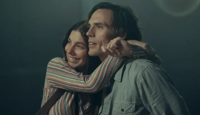 A man and woman hugging each other in a dark room.