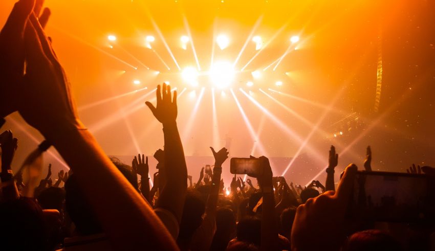 A crowd at a concert with their hands raised.