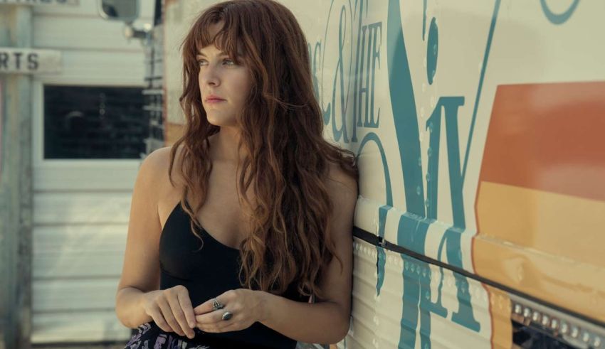 A woman leaning against the side of a rv.
