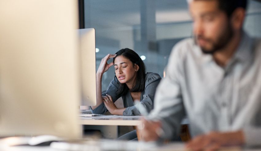A man and woman are sitting in front of a computer.