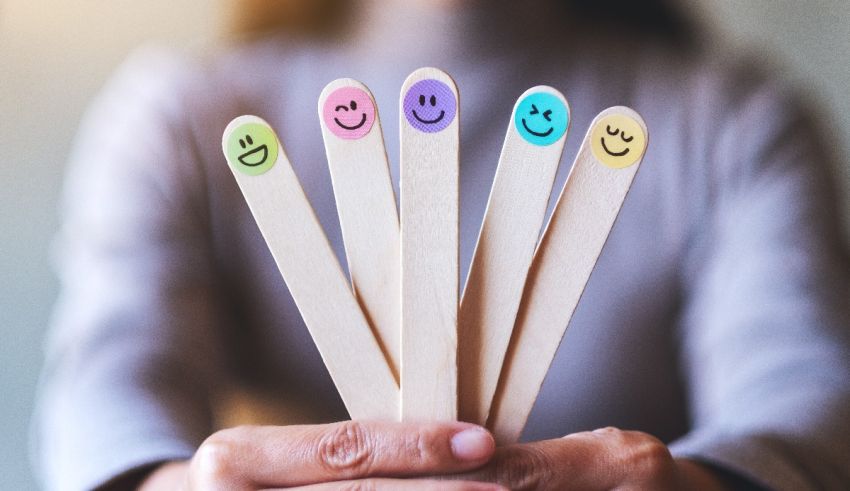 A woman holding a bunch of sticks with smiley faces on them.