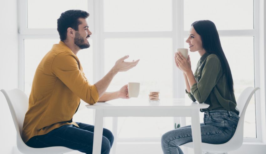 A man and woman sitting at a table talking.