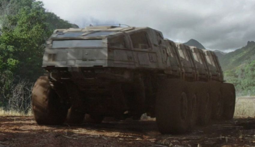 A large truck driving down a dirt road.