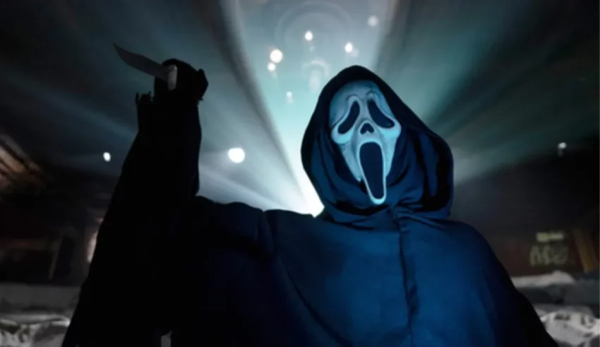 A man in a hooded robe holding a knife.