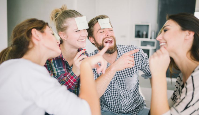 A group of people laughing at a game of tic-tac-toe.
