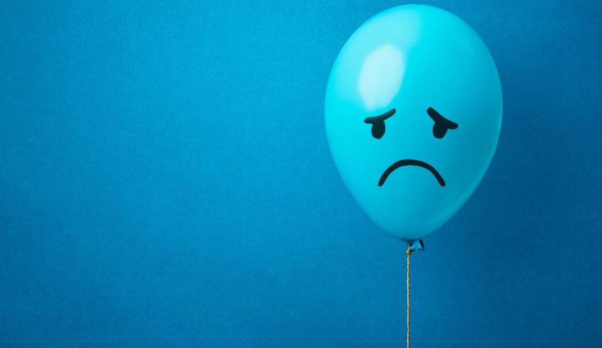 A blue balloon with a sad face on it.