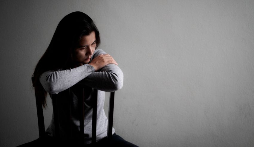 A woman sitting on a chair with her arms crossed.