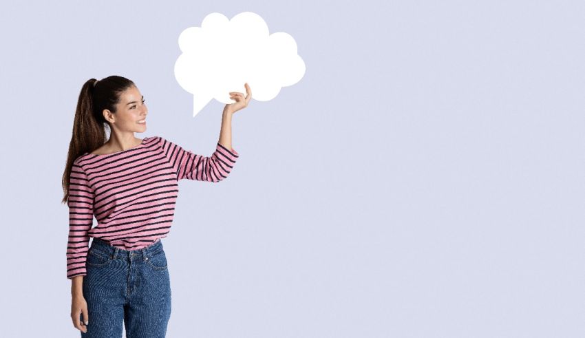 A woman holding a speech bubble over a purple background.