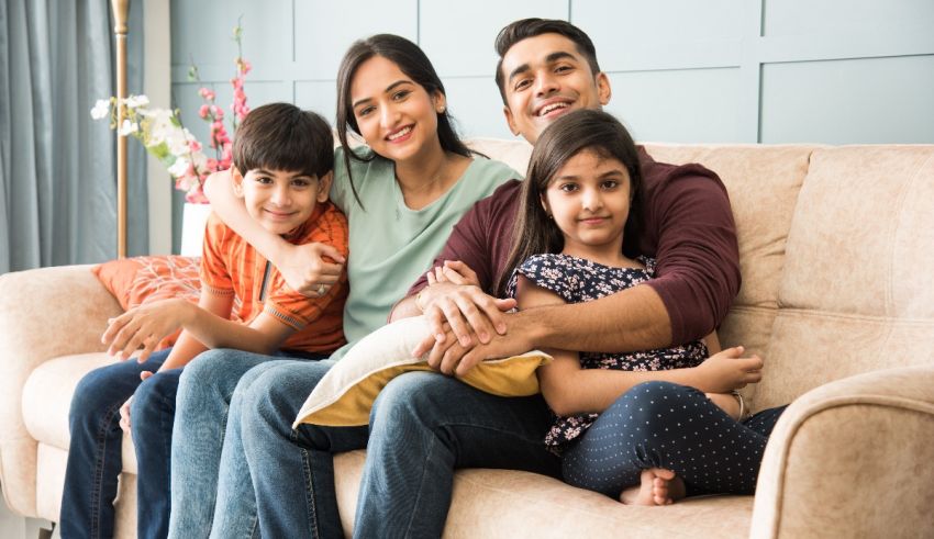 A happy family sitting on a couch at home.