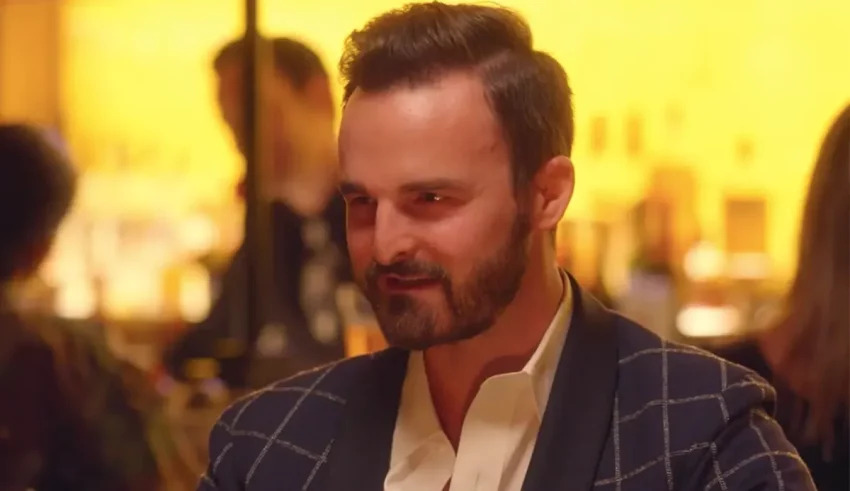 A man with a beard sitting at a bar.