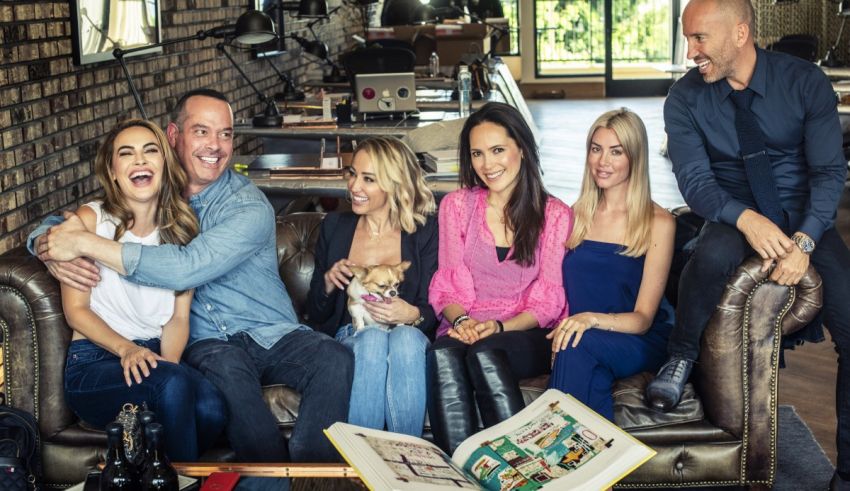 A group of people sitting on a couch with a dog.