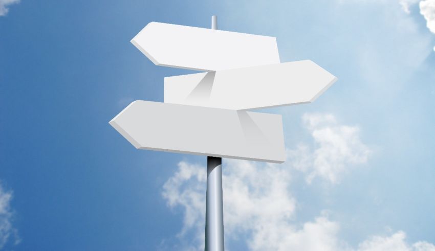 A white sign with arrows pointing in different directions.