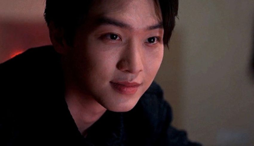 A young man in a black shirt is staring at something.