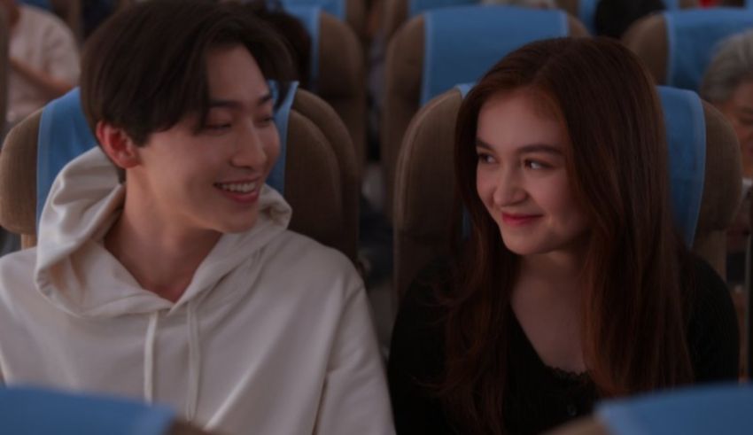 A man and woman sitting in an airplane.