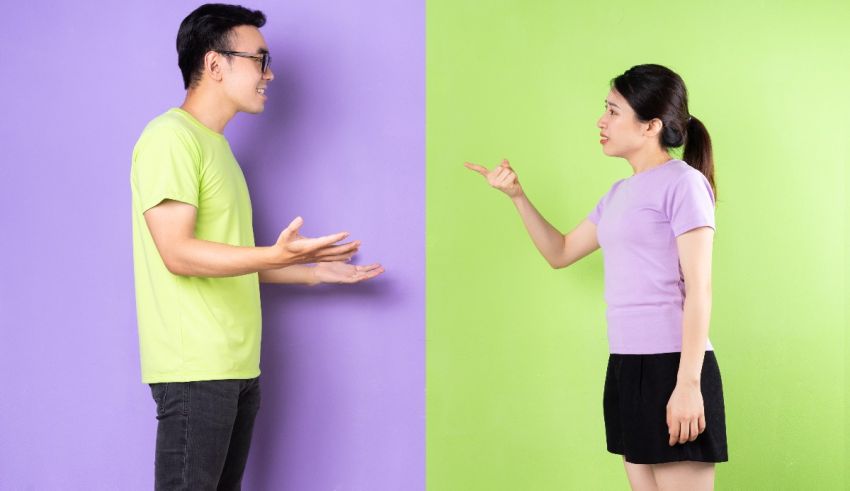 Asian man and woman pointing at each other on a green and purple background.