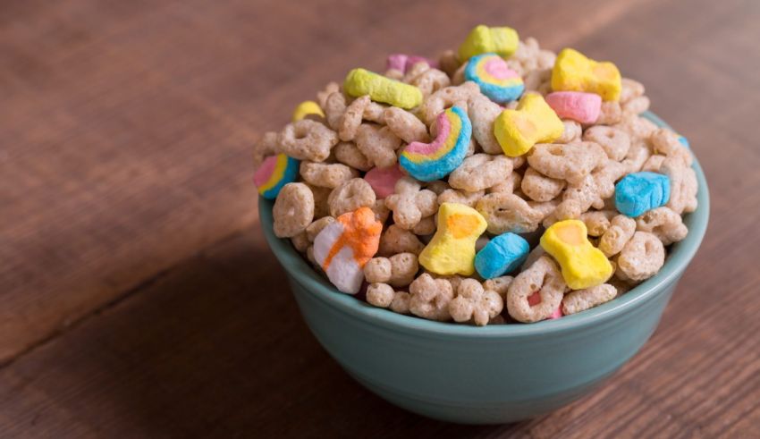 A bowl of cereal with marshmallows in it on a wooden table.