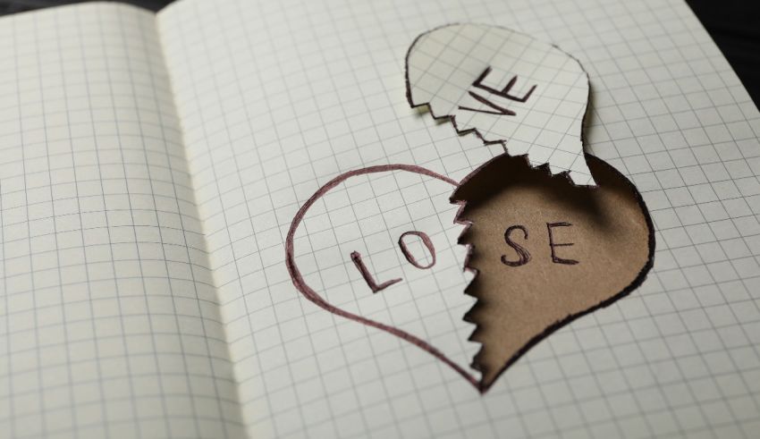 A notebook with a heart cut out and the word lose written on it.