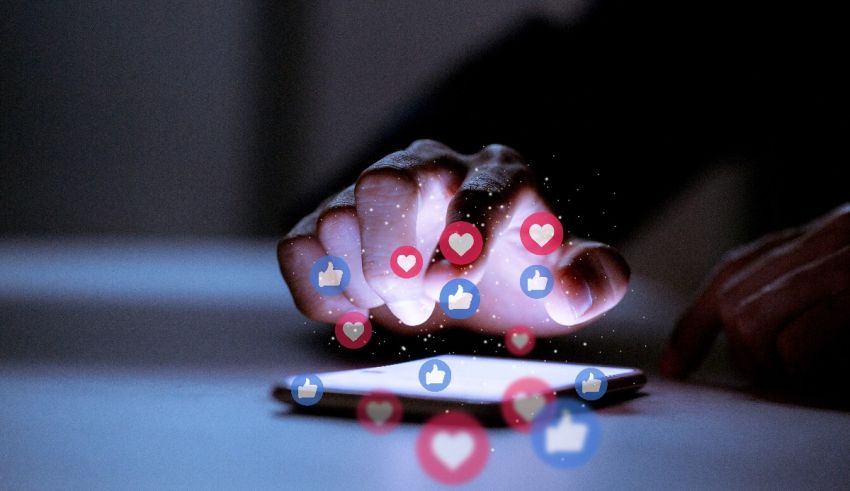 A person holding a phone with social media icons on it.