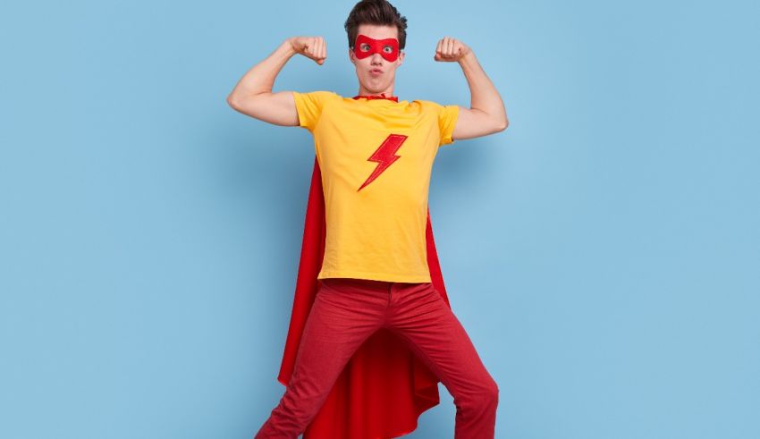 A young man in a superhero costume posing on a blue background.
