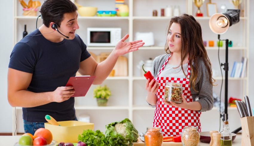 A man and woman in a kitchen talking to each other.