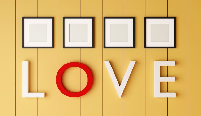 The word love is written on a yellow wall.