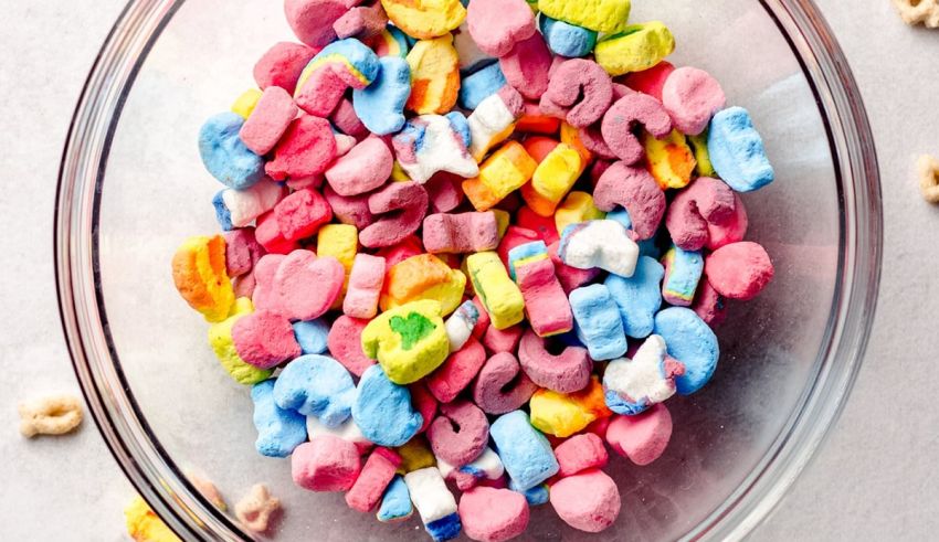 A bowl full of colorful marshmallows on a white background.