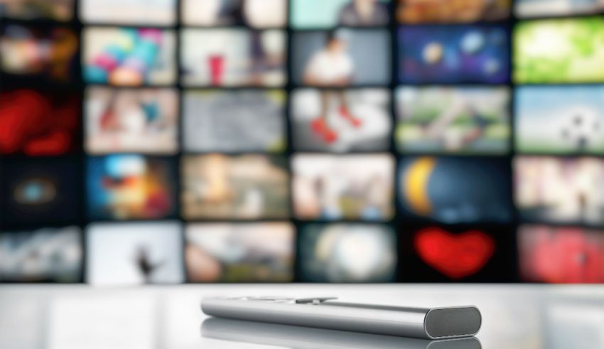 A remote control in front of a television screen.