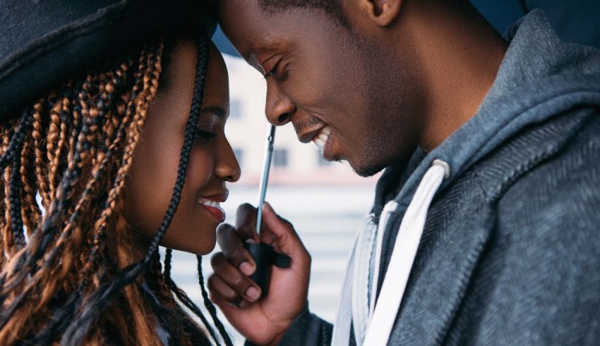 A man and woman are looking at each other under an umbrella.