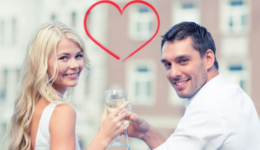 A man and woman holding a glass of wine with a heart in the middle.