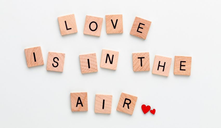 Love is in the air written in wooden blocks on a white background.