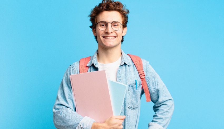 A young man in glasses holding a folder on a blue background.