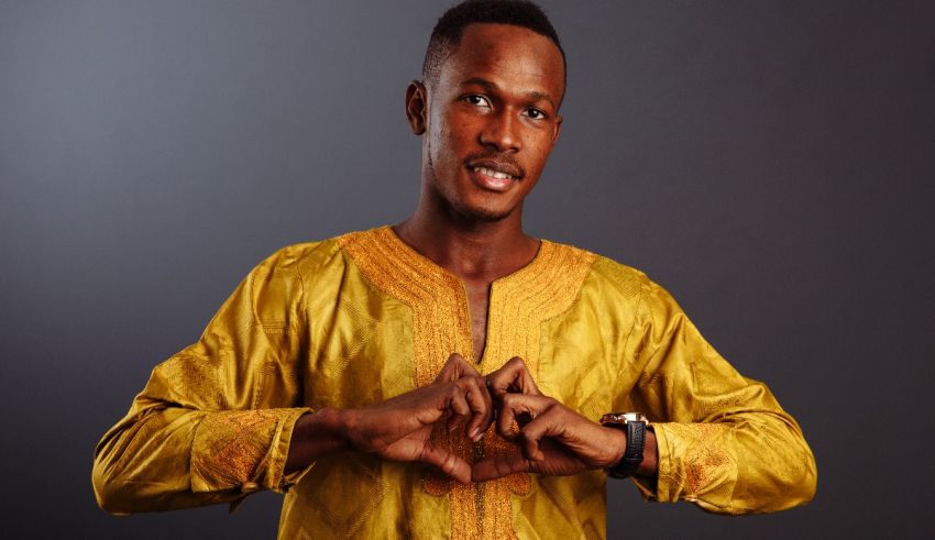 A man in a yellow shirt making a hand gesture.